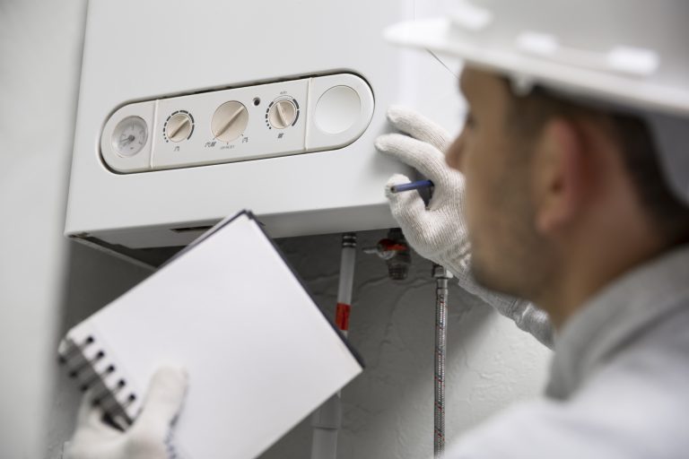 Furnace repair in Pleasanton โ technician inspecting a gas furnace control panel